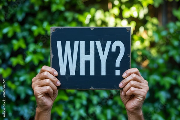 Obraz Hands holding a 'WHY?' sign against a leafy background.