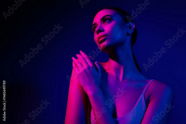 Fototapeta Young woman posing in neon lights with vibrant colors, expressing sensuality and confidence