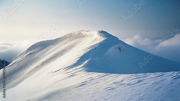 Obraz Snowy mountain peak rising above a landscape of clouds.