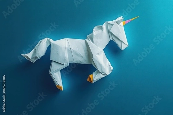Fototapeta White origami unicorn with a colorful horn on a blue background, showcasing detailed paper folds and a playful, imaginative mood