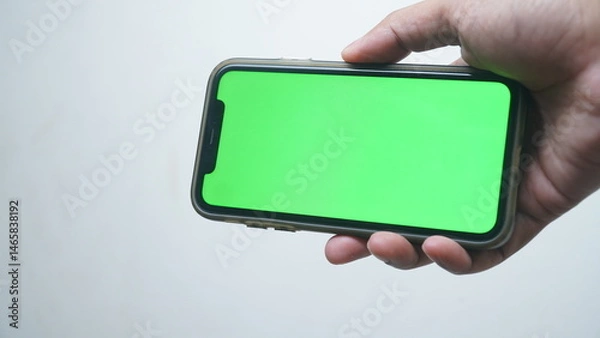 Obraz Man hold smartphone with chroma green screen