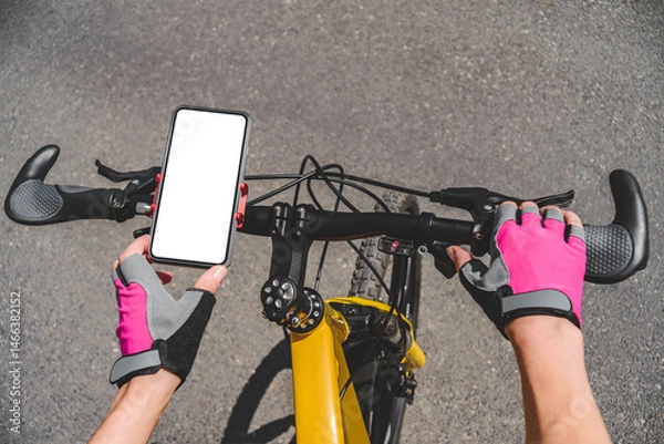Obraz Close-up mockup of a white mobile phone screen on a bicycle handlebar. Background of gray asphalt or concrete on the road outdoors.