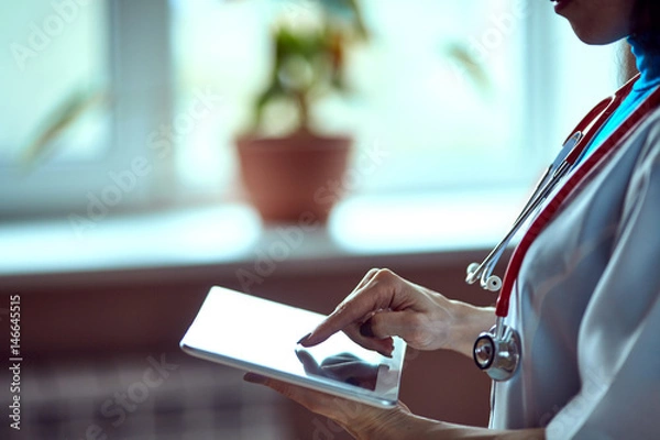 Fototapeta Doctor working on a digital tablet with copy space