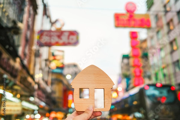 Fototapeta Businessman holding a model house in a shopping area to find a storefront for his business. The idea of ​​whether finding a storefront is still necessary in this era of growing online commerce.	