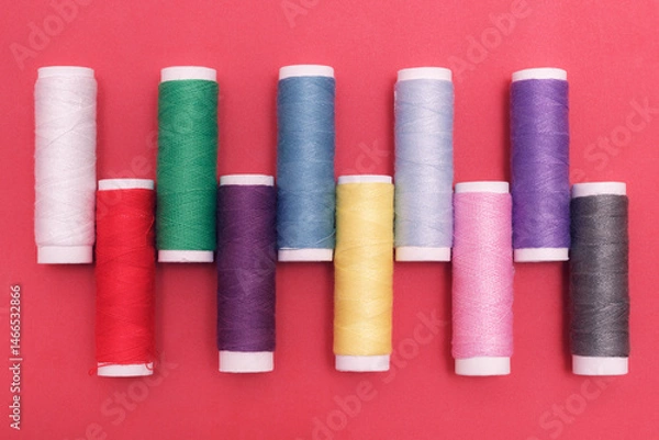 Fototapeta The set of colorful woolen threads in rolls on the pink background. The items for fashion hobby or tailoring.