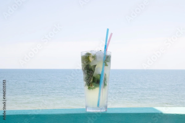 Fototapeta Glass of juice on table by the sea