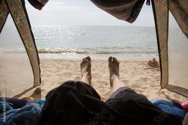 Fototapeta View of feet inside tent at beach