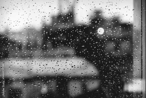 Obraz Raindrops on Window with Blurred City Buildings in Black and White