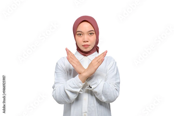 Fototapeta Portrait of young serious Asian Muslim woman showing stop gesture with crossed arms isolated on transparent background