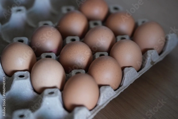 Obraz Brown chicken eggs neatly arranged in a paper tray, ready for cooking