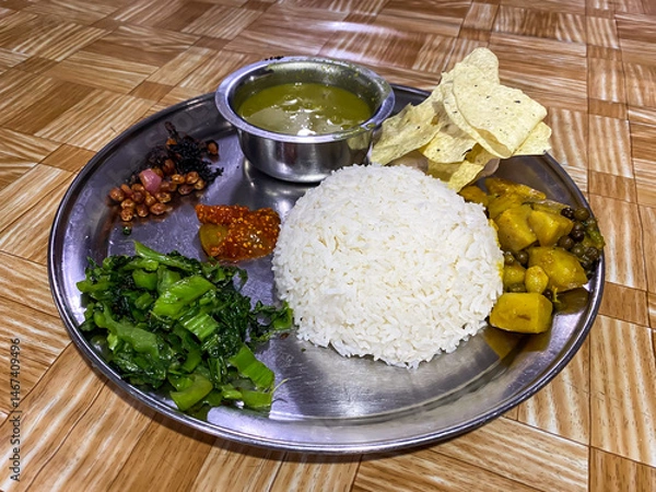 Obraz Dal Bhat is a traditional Nepali meal consisting of lentil soup (dal) served with steamed rice (bhat), often accompanied by vegetables, pickles, and curry for a hearty, balanced dish.