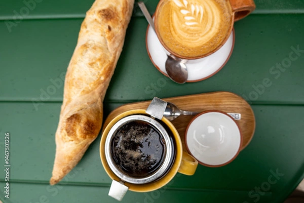 Obraz Kuldiga, Latvia Atable with a fresh sourdough baguette, a cafe latte, and a tea.