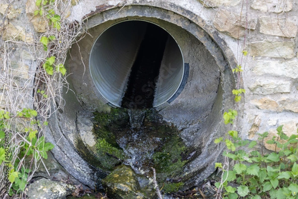 Obraz Kuldiga, Latvia A drainage pipe with a small stream of water.