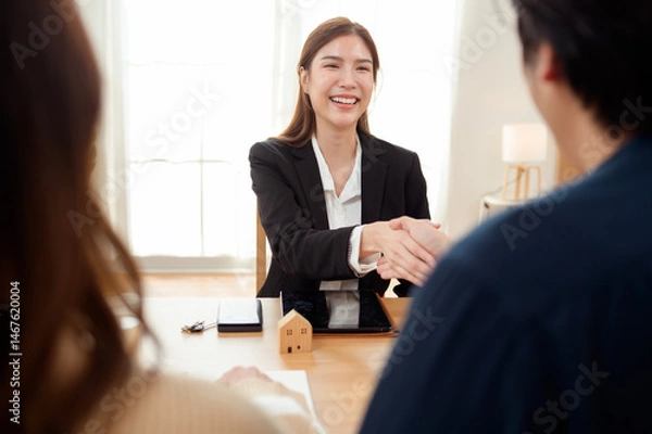 Fototapeta Professional Woman Shaking Hands With Clients in a Bright Office During a Business Meeting