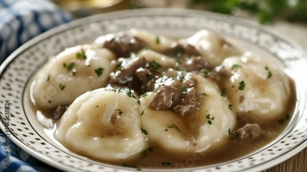 Fototapeta Traditional dumplings, a savory dish with gravy and garnish, close-up shot