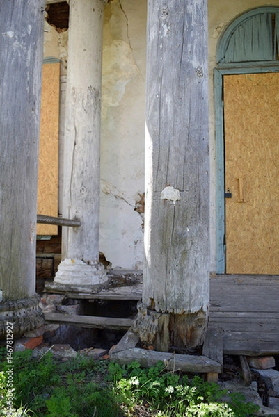 Fototapeta Wooden columns of an ancient 18th century building damaged by time.