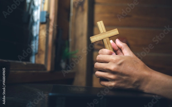 Obraz Close up hands of a man holding Cross and praying on bible ,christian background, devotional concept