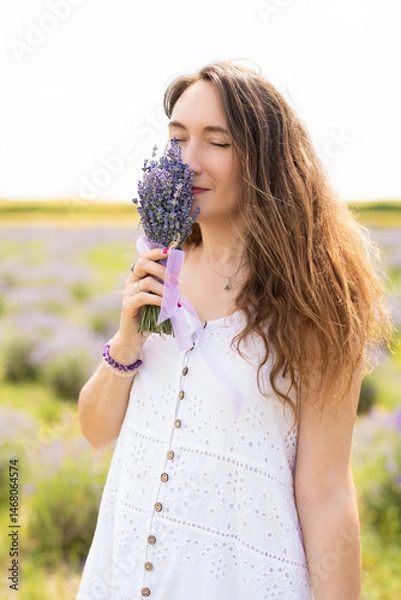 Obraz beautiful girl in a dress on a lavender field with a bouquet of flowers