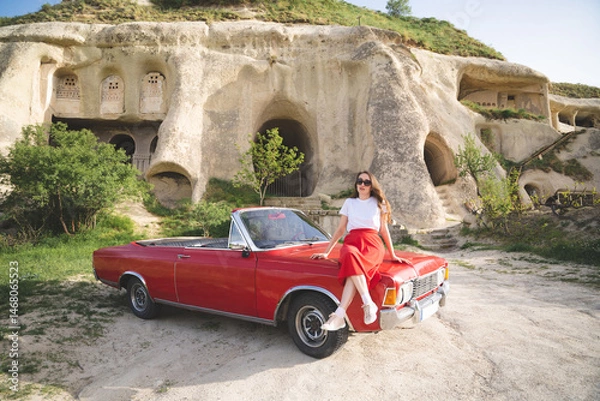 Obraz beautiful happy girl in a skirt posing near a retro car in the mountains of cappadocia