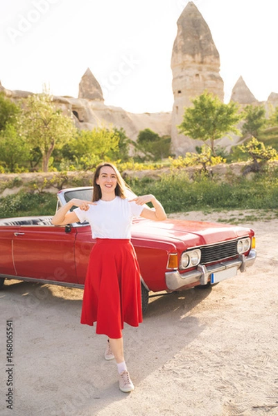 Obraz beautiful happy girl in a skirt posing near a retro car in the mountains of cappadocia