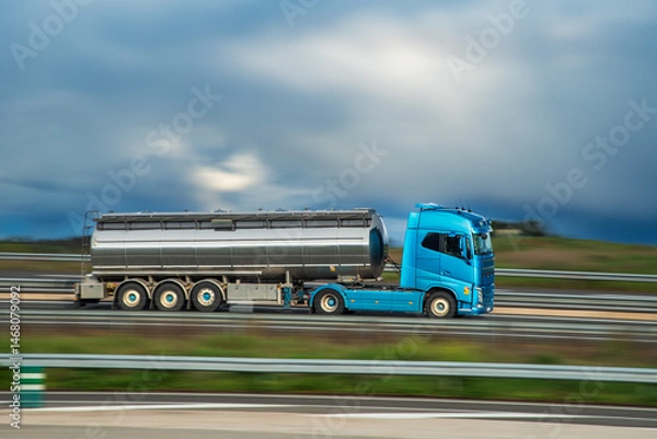 Fototapeta Tanker truck driving on a highway, panning shot with motion blur, side view.