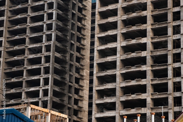 Fototapeta Vertical view of high-rise concrete structure with deep architectural shadows