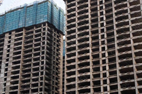 Fototapeta High-rise concrete structure with deep architectural shadows