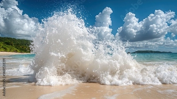 Fototapeta Ocean wave crashing on a tropical beach. Lush tropical foliage visible in the background