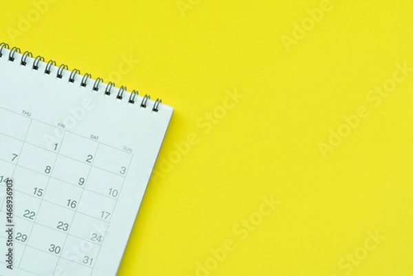 Fototapeta close up of calendar on the yellow table background, planning for business meeting or travel planning concept
