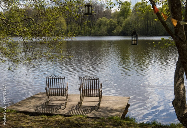 Fototapeta chaises pour se détendre et se reposer au calme en bourgogne devant le lac de Chamboux dans le parc du Morvan au printemps