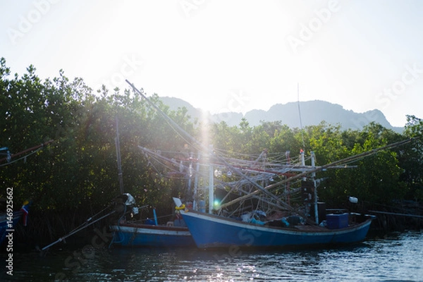 Fototapeta wood fishing boat anchor on sea get ready for trawl. around this place filled nature and mangrove forest background, this image for nature,fishing and boat concept