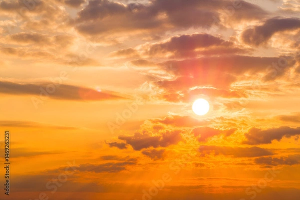 Fototapeta Dramatic sunset with sun rays through orange clouds