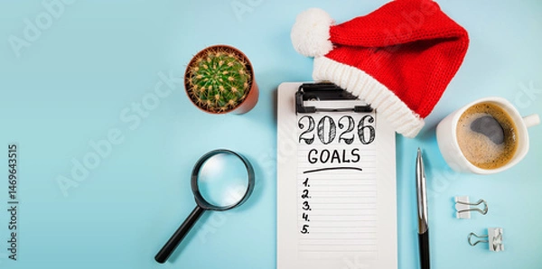 Fototapeta New year resolutions 2026 on desk. 2026 goals list with notebook, coffee cup, plant on blue table. Resolutions, plan, goals, action, checklist, idea concept. New Year 2026 resolutions, copy space