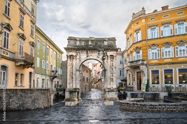Fototapeta Stunning view of the Roman Gate in Pula, Croatia surrounded by historic architecture and vibrant buildings