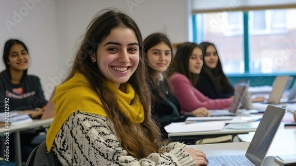 Fototapeta A diverse group of six students sitting in a modern classroom, smiling and laughing together.