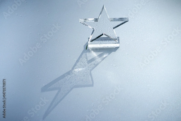 Obraz Transparent glass star on a silver background.A photo of the prize in the form of a five-pointed star on a pedestal.A reward for the winner.