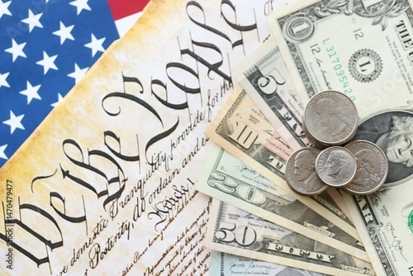 Fototapeta American US dollars money bills with coins and constitution close up on american flag