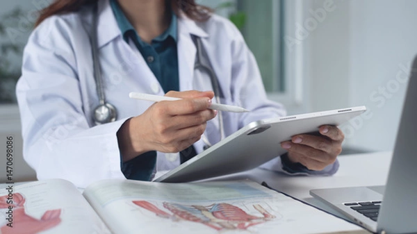 Obraz Medical student using digital tablet and laptop in research education. Internship doctor searching the information at doctor's office, medical research. Healthcare and medicine, closeup