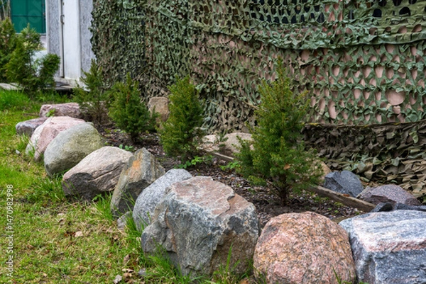 Fototapeta Garden bed with rocks and evergreen trees