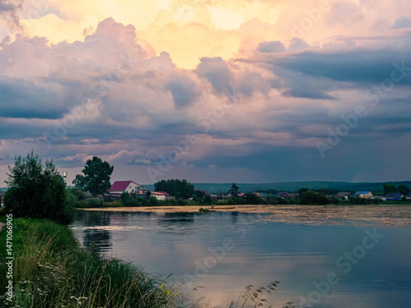 Fototapeta Majestic sunset over tranquil river with colorful clouds reflecting on the water