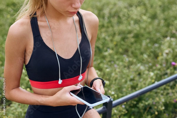 Fototapeta Fitness woman using smart phone and a watch