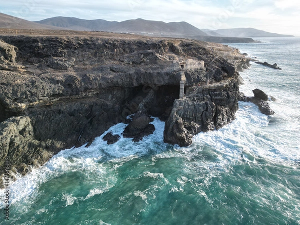 Fototapeta waves breaking on rocks