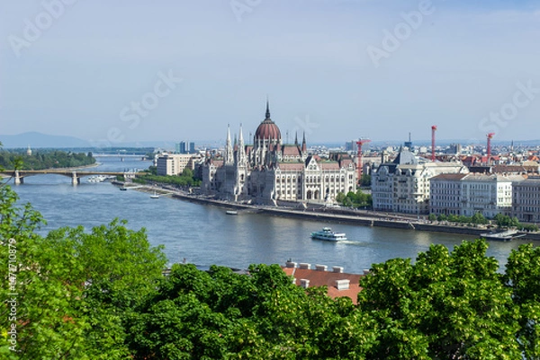 Fototapeta Panoramic view of Budapest city with Parliament building, Danube River, bridges and green trees under clear blue sky