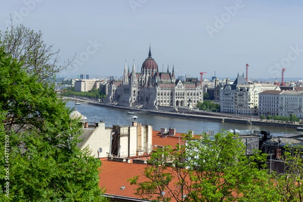 Fototapeta Panoramic view of Budapest city with Parliament building, Danube River, bridges and green trees under clear blue sky
