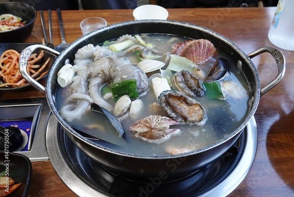 Fototapeta A bowl of flavorful seafood stew with octopus, clams