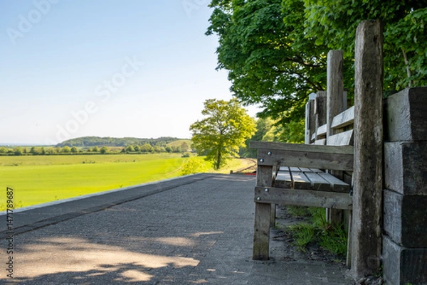 Fototapeta Wooden benches on Kelling rail station on the North Norfolk Railway Line. Captured on a sunny morning Intentional sharp focus and bokeh