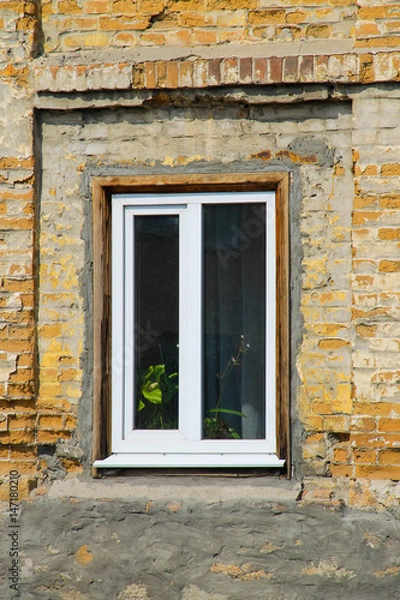 Fototapeta Modern plastic window on old brick wall