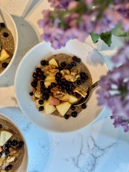 Fototapeta Healthy vitamin-rich balanced vegan breakfast. Raw flaxseed porridge with apples, walnuts, berries. Useful homemade veggie lunch. Vitamins, minerals. Gluten sugar free.	Lilac flowers in a frame.