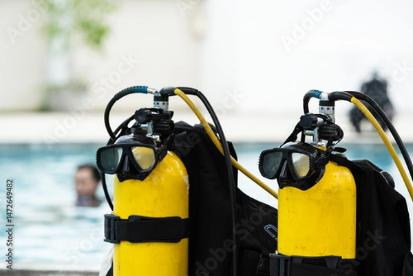 Fototapeta Scuba diving equipment on swimming pool.Diving mask and yellow oxygen tank for water rescue training on the pool background.