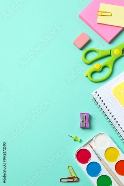 Obraz A vertical collection of brightly colored school supplies including notebook, stationery, and scissors displayed on a color background